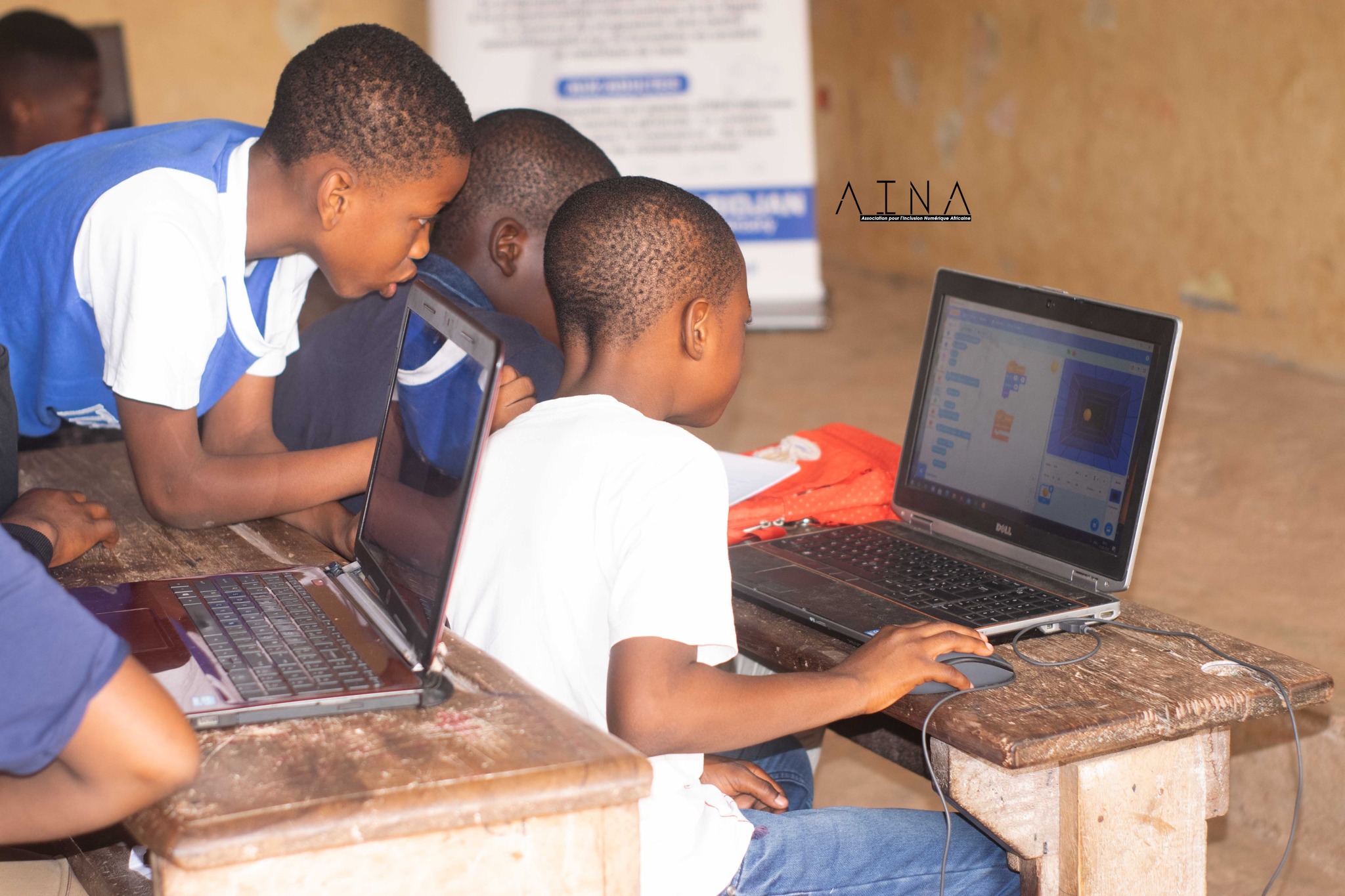 Three students focused on Scratch