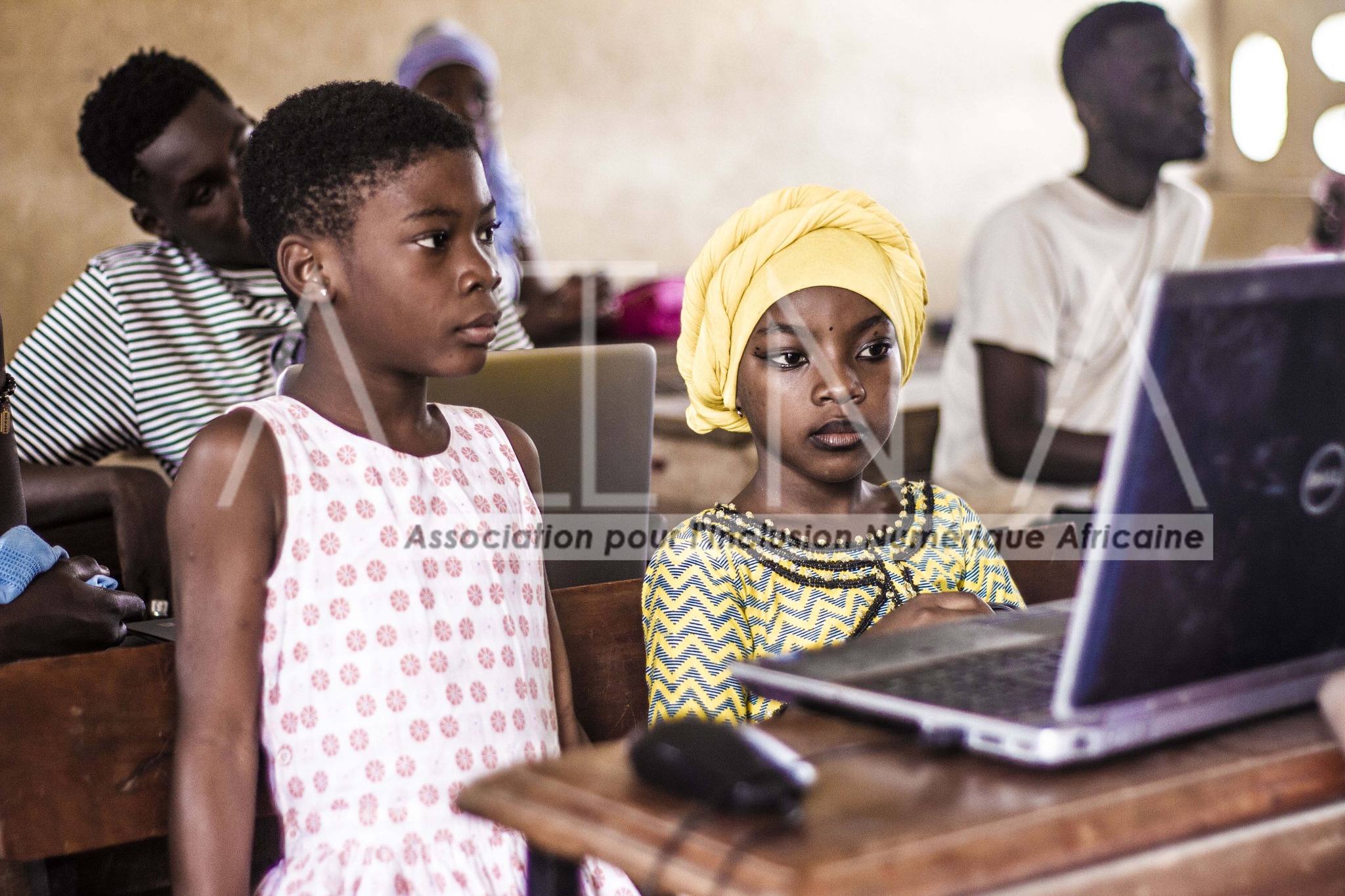 Two students focused on a laptop
